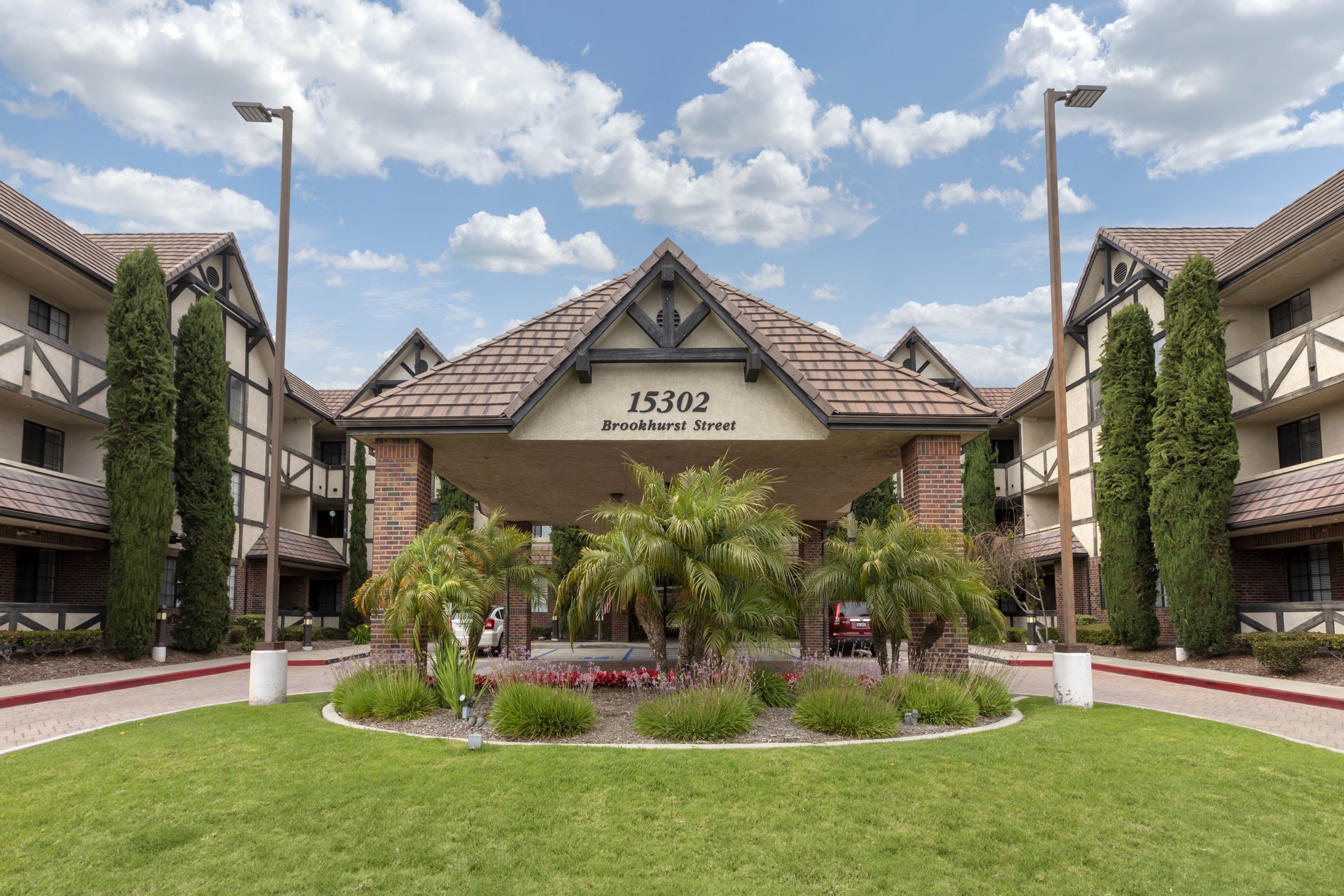 The front of the community: a Tudor-framed building behind a lawn and mature palms